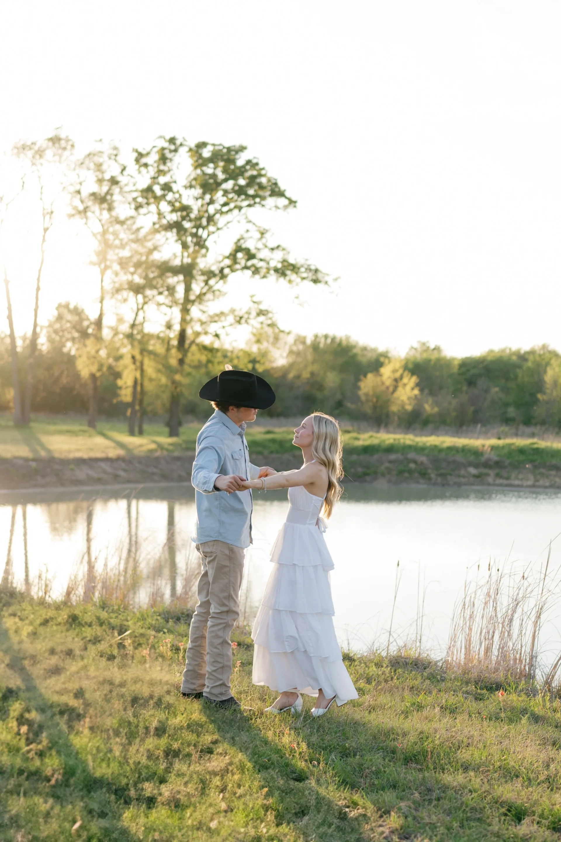 Couple slow dancing at the edge of a Texas pond in fading light